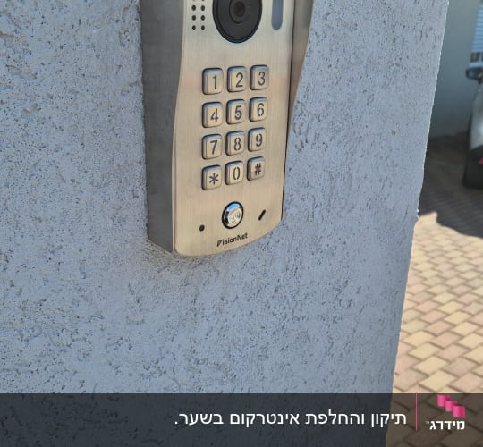 אינטרקום עם מצלמה ומקשים על קיר חיצוני